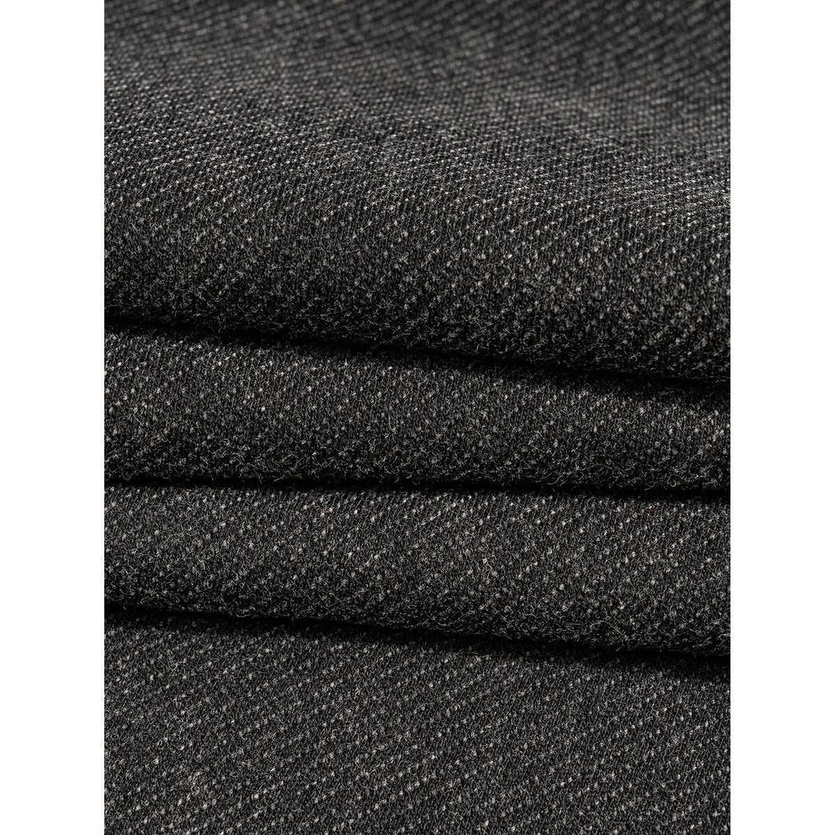 Close-up of stacked black fabric with a textured pattern