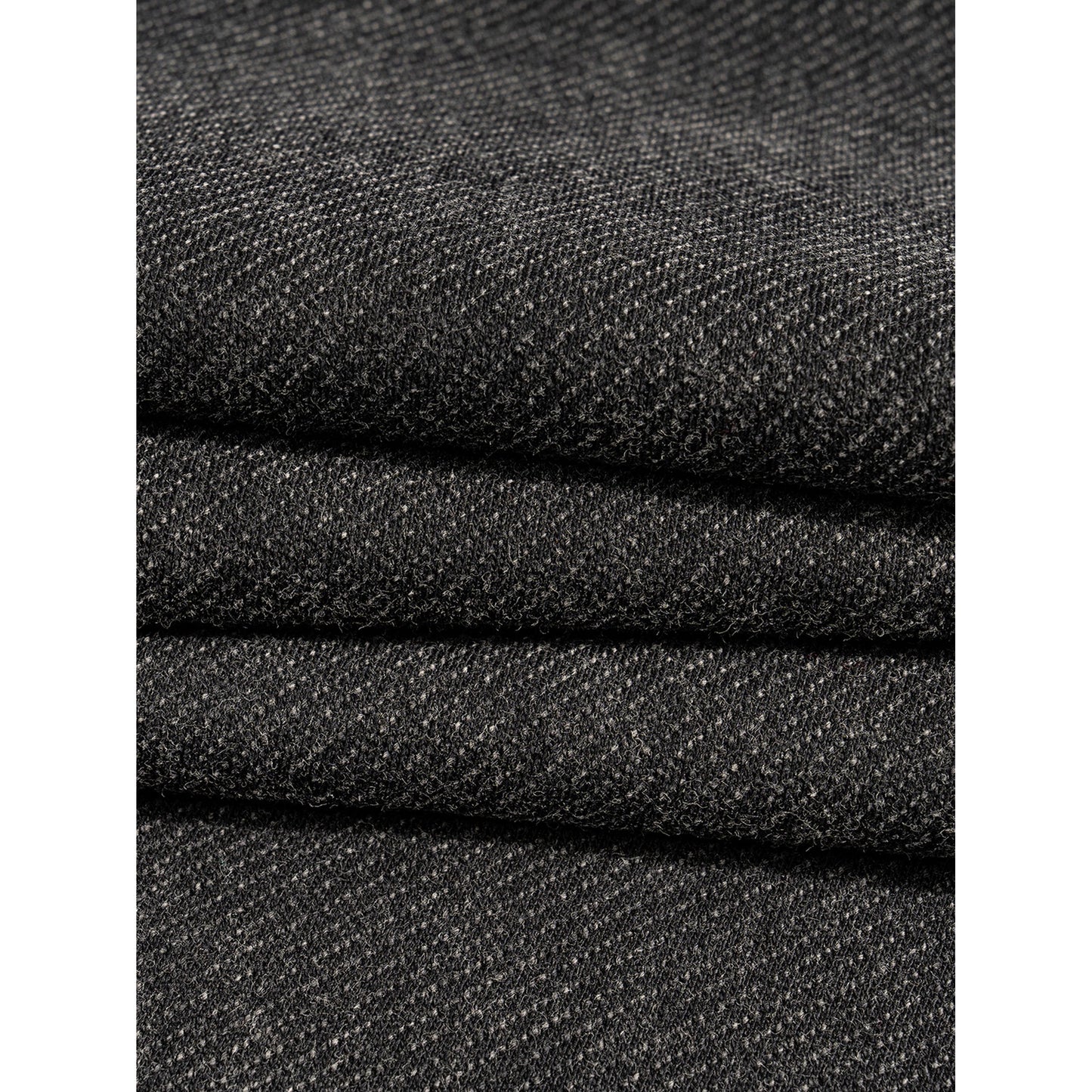 Close-up of stacked black fabric with a textured pattern