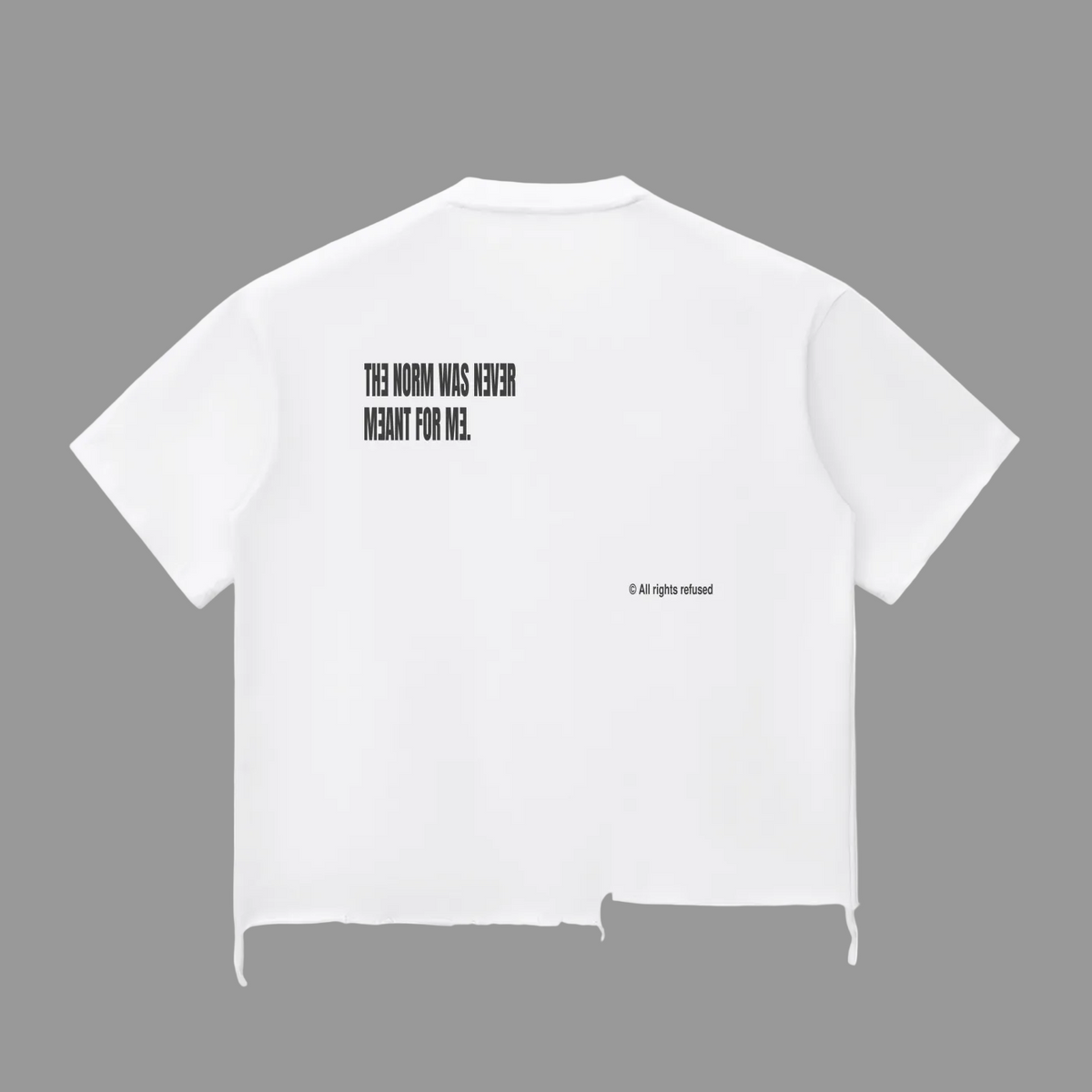 The Rebel Tee in white, back view — heavyweight cotton boxy tee with raw distressed hem, “The Norm Was Never Meant For Me” graphic and “© All Rights Refused” detail