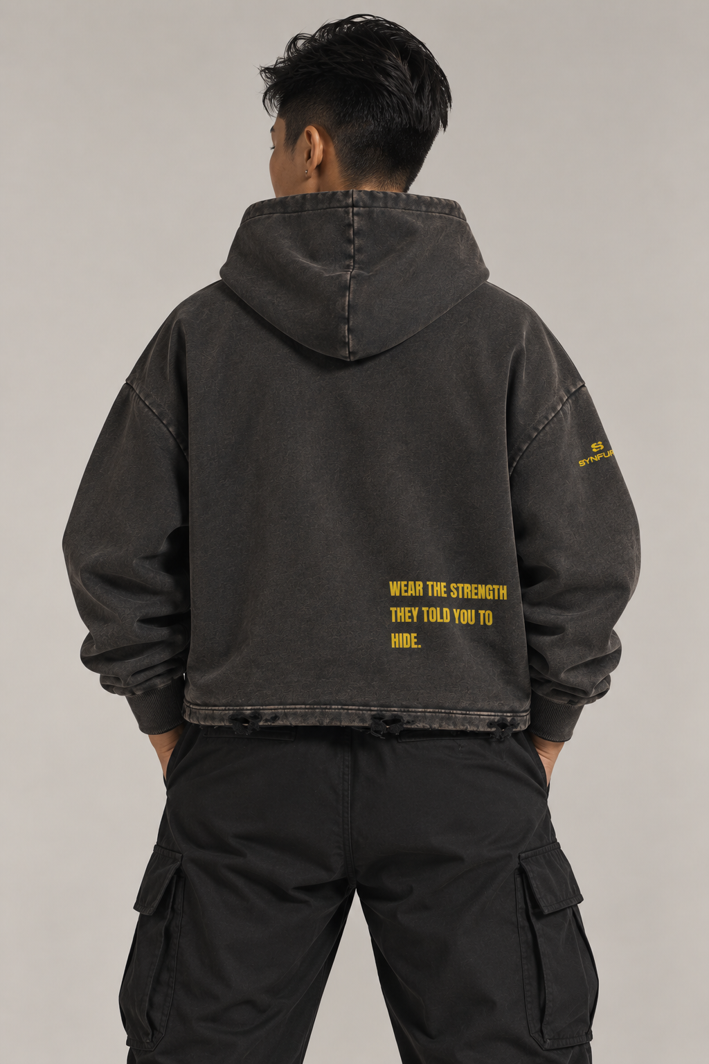 SYNFURY cropped hoodie in washed black, back print "Wear The Strength They Told You To Hide