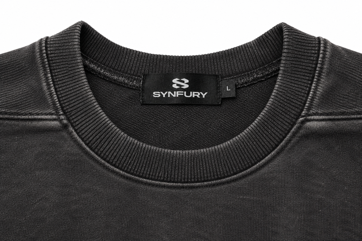 Close-up of ribbed collar with woven SYNFURY neck label and size tag, heavyweight cotton