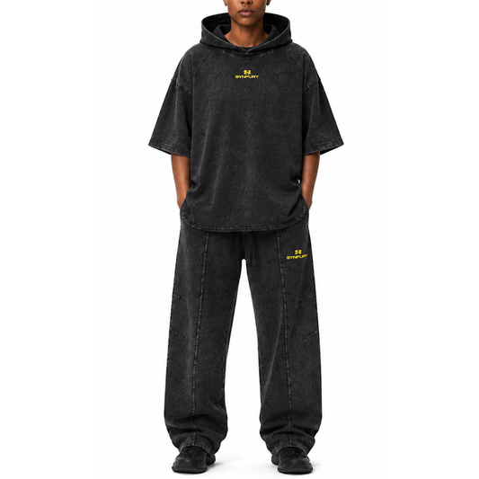 A model wearing a matching Cinder Black -wash hoodie and Trail sweatpants set with yellow embroidered 'SYNFURY' logos, shown against a plain white background.