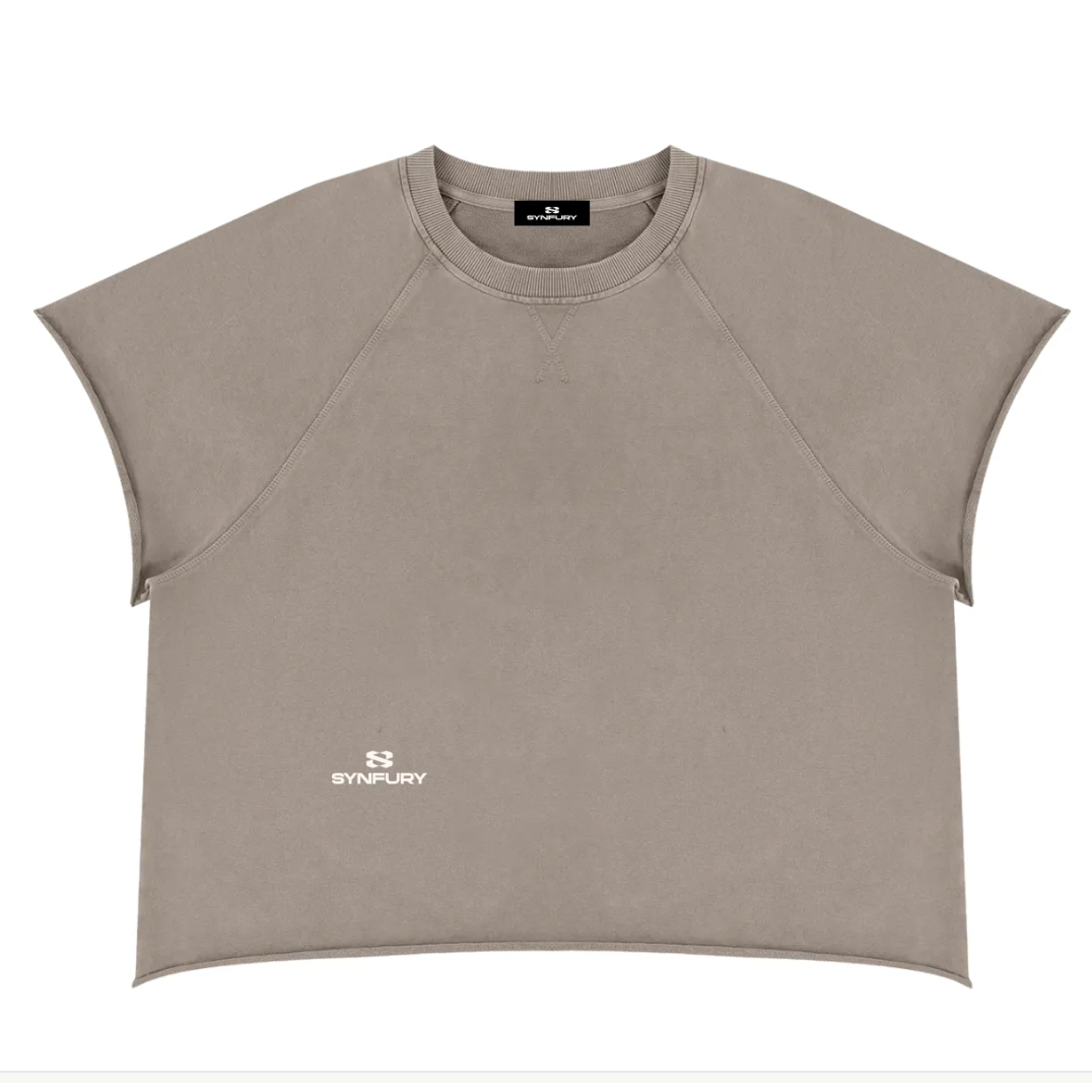 A cropped short-sleeve athletic top in taupe with a small white SYNFURY logo on the lower left chest, displayed flat against a white background.