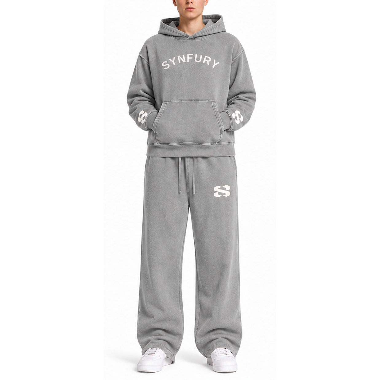 A model wearing a matching gray washed sweatshirt and sweatpants set with white 'SYNFURY' text on the chest and white sneakers, photographed against a plain white background.